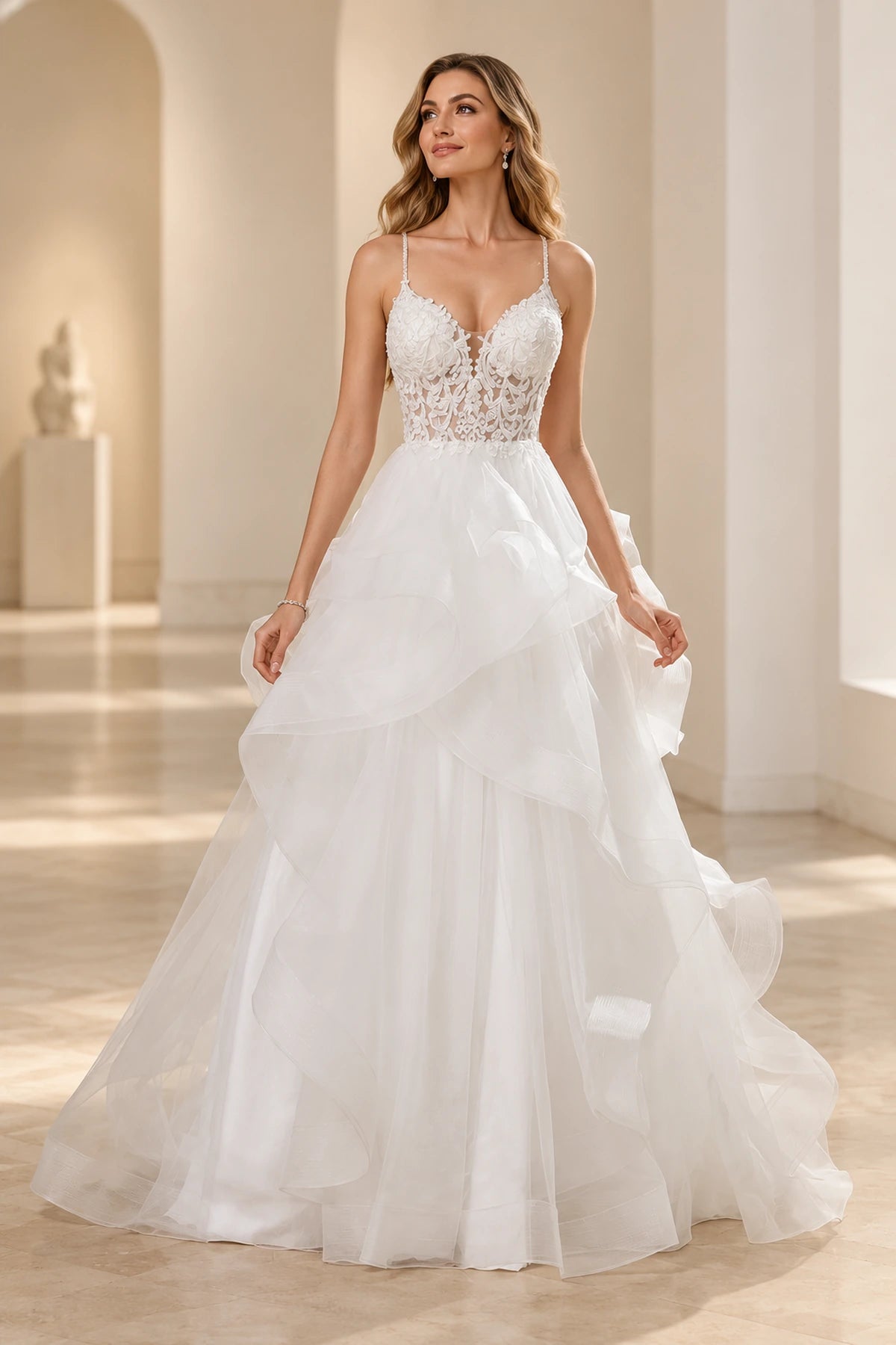 Vedress A-line tulle wedding dress with a plunging V-neck, sheer floral lace bodice, spaghetti straps and cascading ruffle skirt, front view.